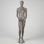 1400 damemannken. Grå, matt med hode, ansikt og skulpturert hår. H 178 cm. Hender foran